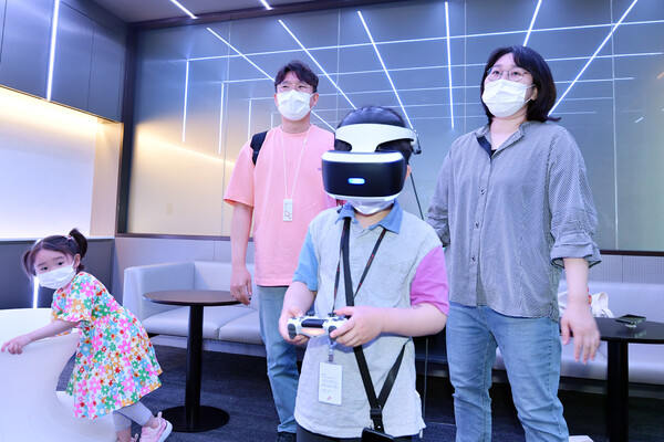 SKI계열 구성원 가족이 VR 게임 룸에서 가상현실 체험을 하고 있다. (사진=SK이노베이션)