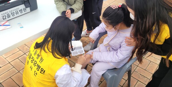 갑을장유병원 의료진이 ‘율하카페거리 벚꽃축제’를 즐기다 다친 어린이를 치료하고 있다.
