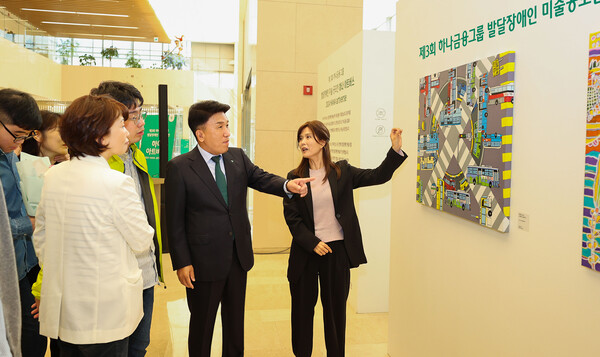 함영주 하나금융그룹 회장(사진 오른쪽에서 두 번째)이 이날 성인 부문 대상 수상작인 박재영 작가의 "신호등이 고장 났어요" 작품 앞에서 설명을 듣고 있다. [사진=하나금융그룹 제공]