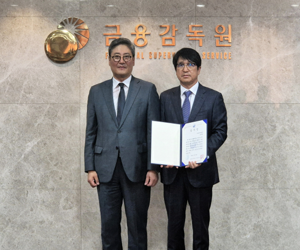 민왕일 현대백화점 경영지원본부 부사장(오른쪽)이 금융감독원으로부터 XBRL 재무 공시 우수법인 감사장을 수여받은 뒤 김정태 금융감독원 공시조사 부원장보와 기념사진을 촬영하고 있다. [사진=현대백화점 제공]