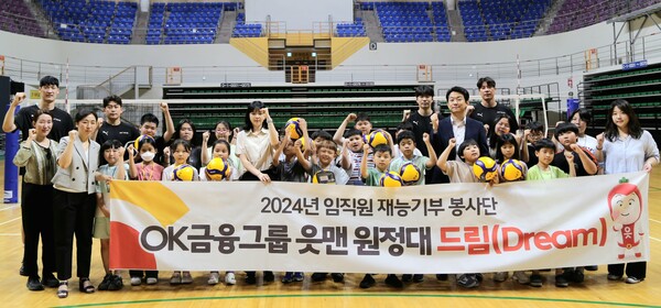 읏맨 프로배구단 홈구장인 ‘안산시 상록수 체육관’에서 진행한 금융교육 및 배구교실 수업을 마친 후 OK금융그룹 임직원들과 읏맨 프로배구단 선수들이 돌봄아동들과 함께 단체촬영을 하고 있는 모습. [사진=OK금융그룹]