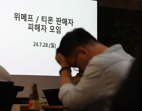 지난 7월 열린 '티몬·위메프 피해 입점 판매자 대책회의'에서 한 참석자가 머리를 쥐고 있다. 사진=연합뉴스