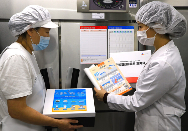 지난 28일 서울시 마포구 아현실버복지관 급식 조리실에서 CJ프레시웨이 식품안전 담당자가 (왼쪽)조리사에게 위생안전 솔루션을 제공하고 있다. (사진=CJ프레시웨이)