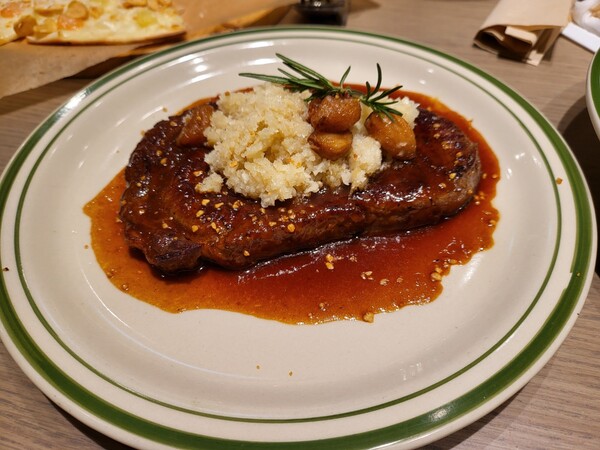 등심으로 구운 스테이크. 스테이크 위에 구운 마늘과 다진 마늘이 올라가 있다. (사진=구변경기자)