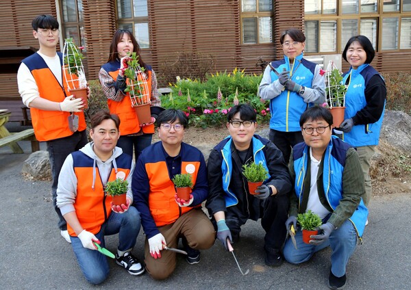 파란꿈터 꽃밭 가꾸기 행사에 참여한 애경산업 직원들과 보둠봉사단 자원봉사자들이 기념촬영을 하고 있다. (사진=애경산업)
