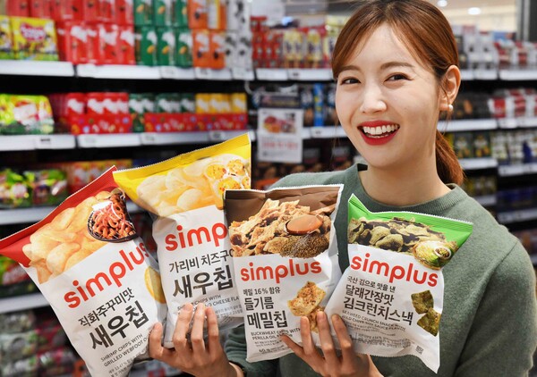 모델이 10일 ‘홈플러스 메가 푸드 마켓 라이브’ 강서점에서 심플러스 봄 제철스낵 4종을 들어 보이고 있다. (사진=홈플러스)