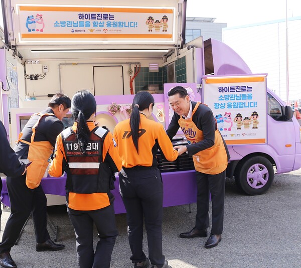 지난 16일 전남 목포소방서에서 김인규 하이트진로 대표(오른쪽)가 소방공무원에게 간식을 전달하고 있다. (사진=하이트진로)