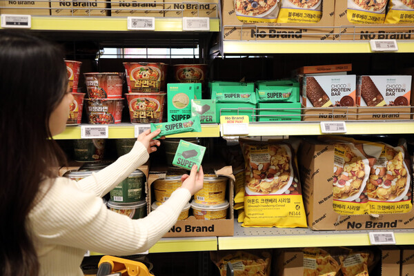 이마트 노브랜드 매대에서 한 소비자가 PB상품을 들어보이고 있다. (사진=이마트)