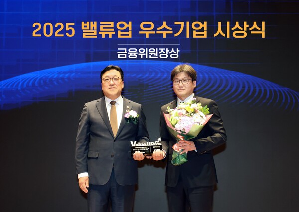 27일 오후 서울 여의도 한국거래소에서 열린 '2025 밸류업 우수기업 시상식'에서 장석훈 삼양식품 경영지원본부장(오른쪽)과 김병환 금융위원회 위원장(왼쪽)이 기념 촬영을 하고 있다. (사진=삼양식품)