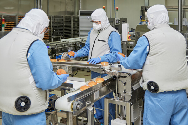 던킨 안양공장 직원들이 온열 질환 예방을 위해 마련된 냉풍조끼를 입고 작업하는 모습.(사진=SPC그룹)