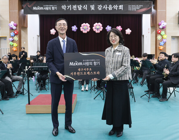 13일 대구서부초등학교에서 열린 '제18회 맥심 사랑의 향기' 행사에서 (왼쪽)최상인 동서식품 홍보상무와 이보경 대구서부초등학교 교장이 기념촬영을 하고 있다. (사진=동서식품)